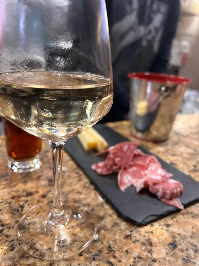 Verre de vin blanc et planche de charcuterie au comptoir