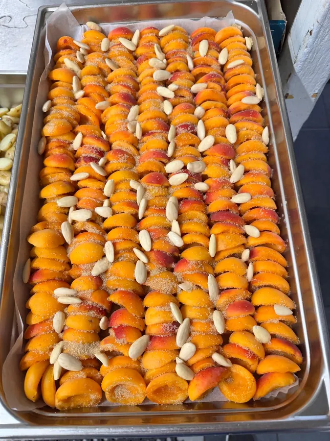 Abricots et amandes alignés avant la cuisson